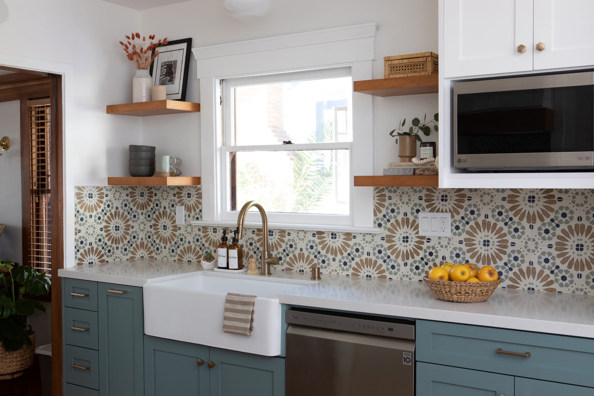 Cottage kitchen with teal cabinets, farmhouse sink and colorful patterned tile backsplash