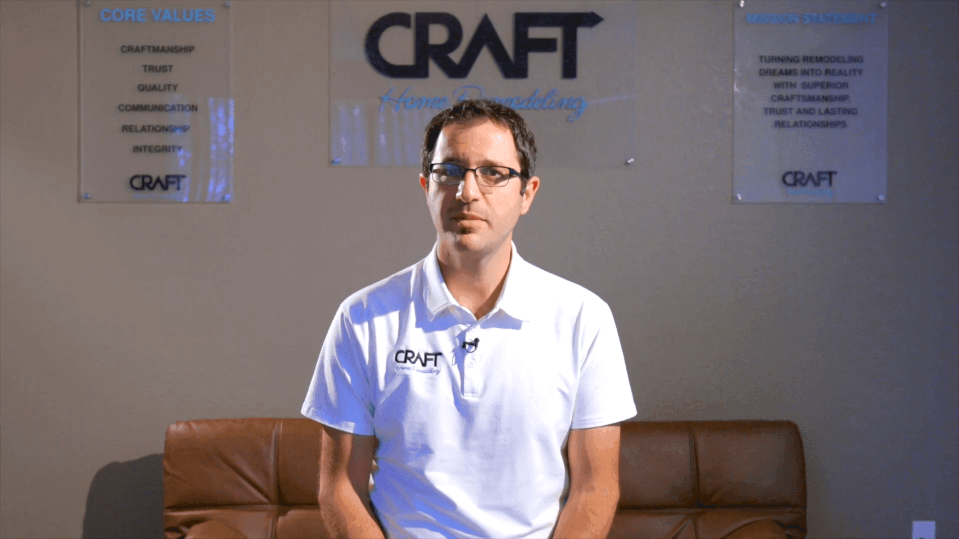 Craft Home Remodeling team member speaking on camera in front of the company core-values display